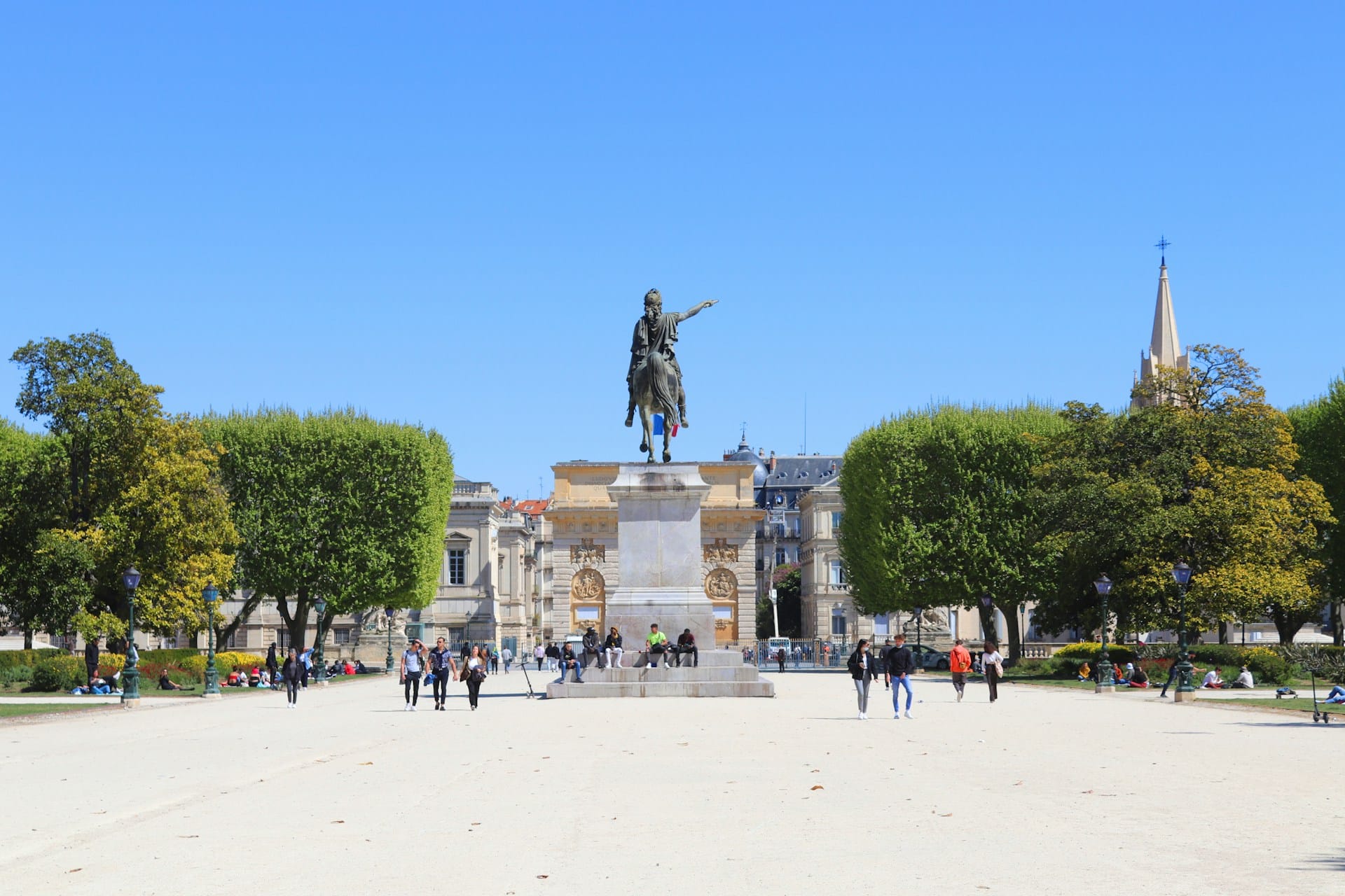 Statue équestre dans un parc avec visiteurs.