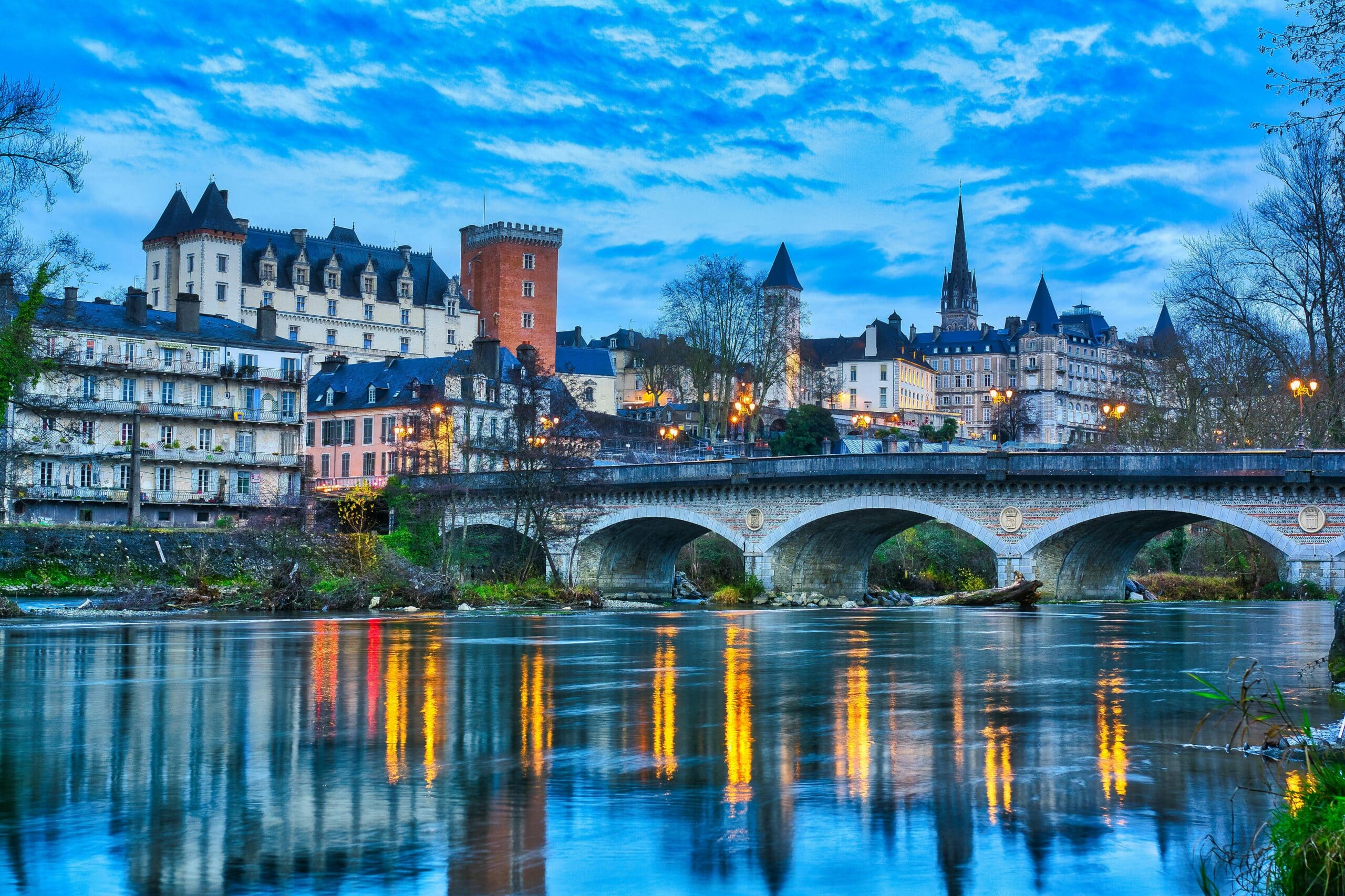 Pont médiéval sur rivière avec reflets lumineux.