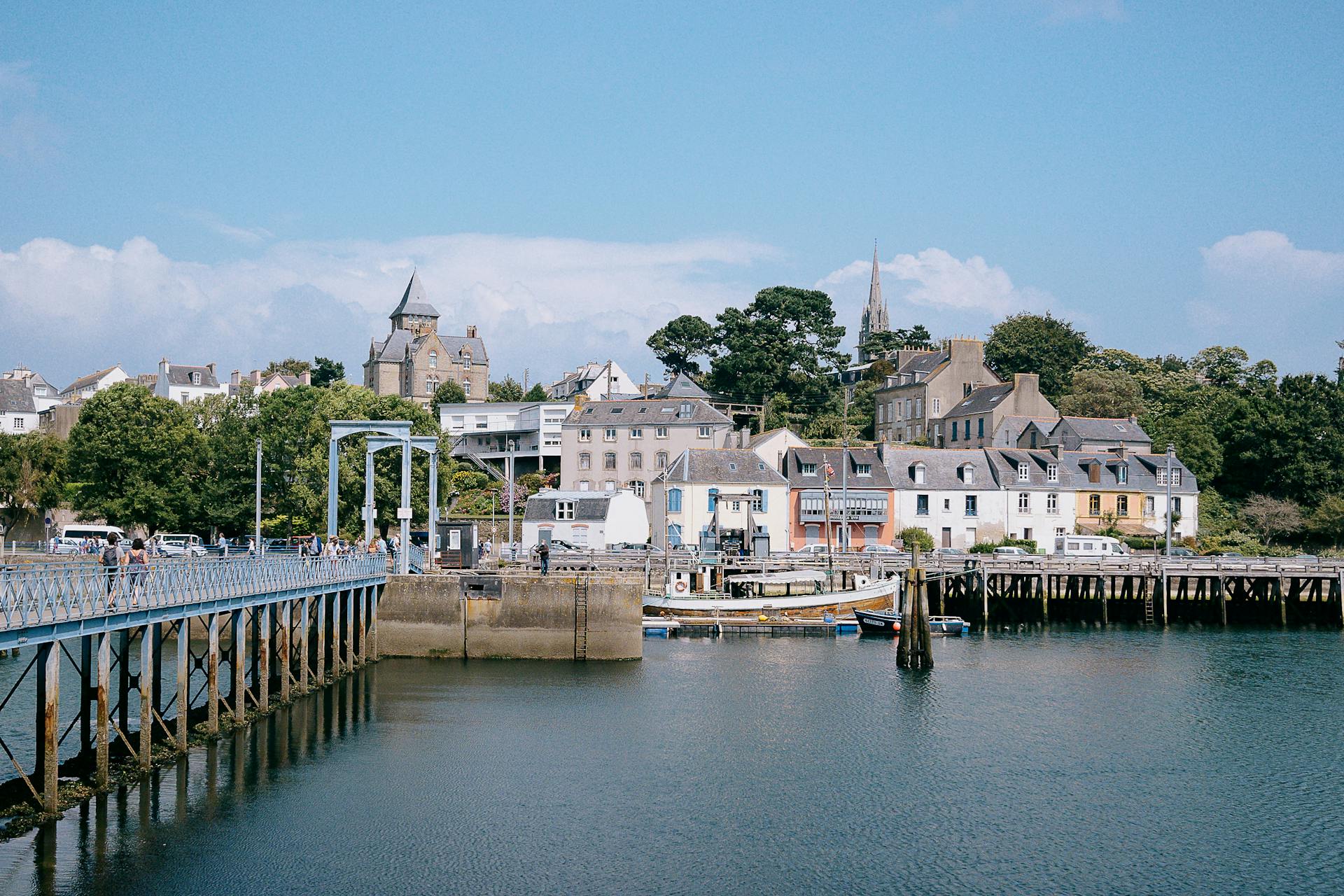 Port breton avec maisons et pont métallique.