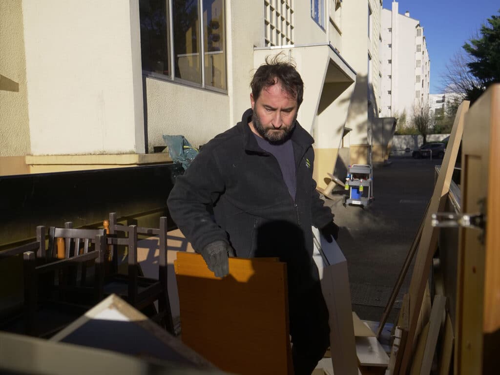 Homme déplaçant du mobilier en extérieur