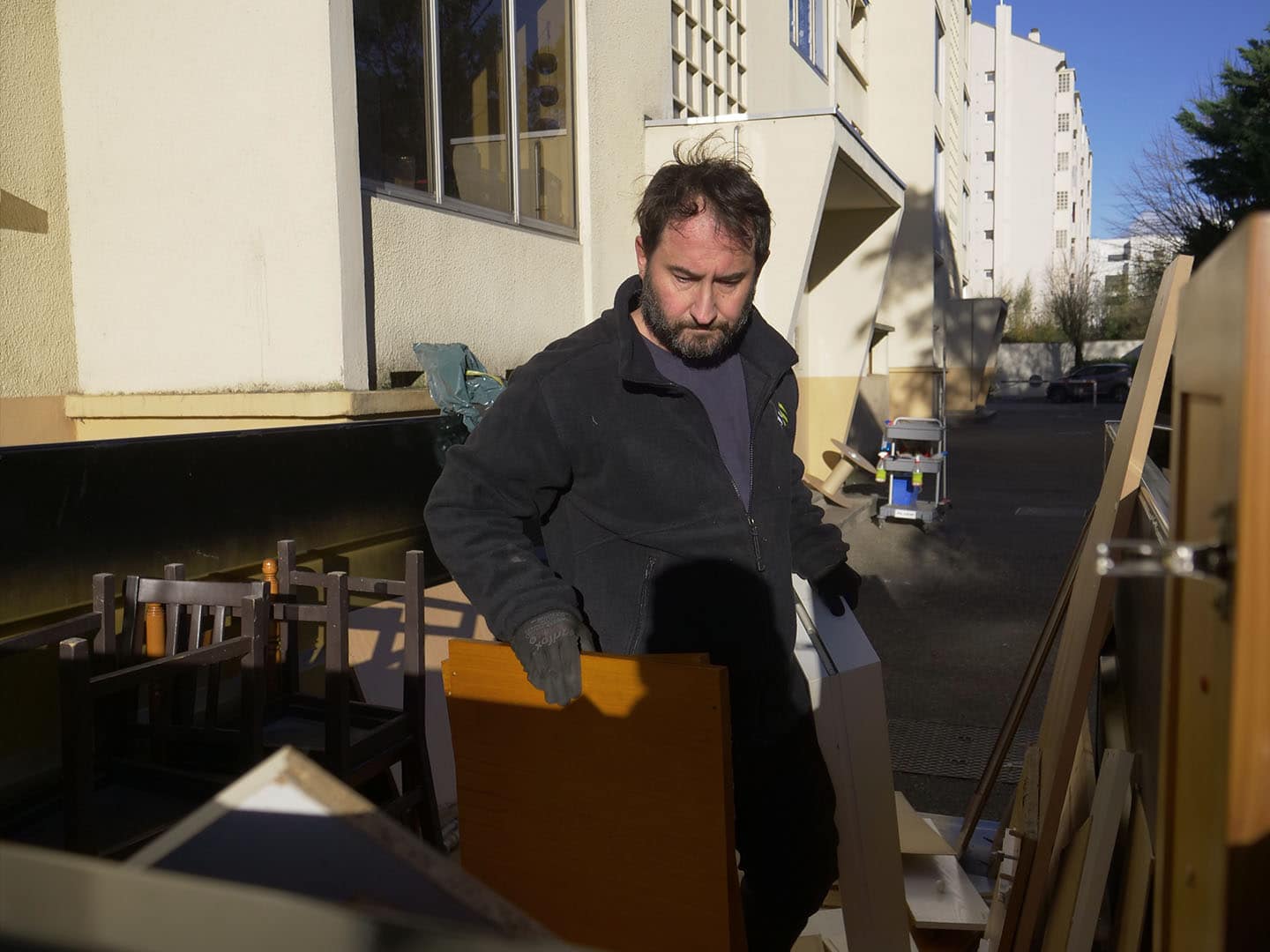 Homme déplaçant du mobilier en extérieur