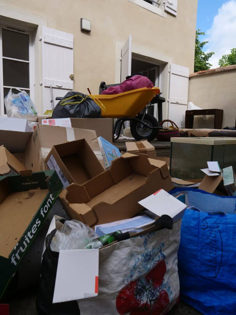 Déchets et encombrants devant une maison.